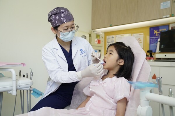 口腔科醫(yī)生正在為小朋友做年度口腔檢查